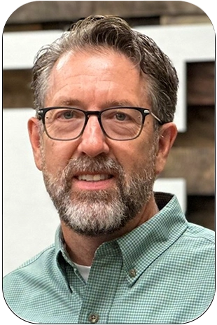 Scott-Eggleston-300px a professional headshot of scott eggleston in a green button down shirt and glasses smiling at the camera